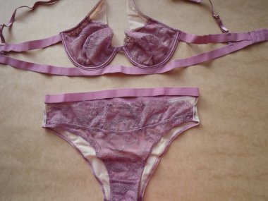 Pembe leylak rengi Guipure. Bej arka planda seksi kadın iç çamaşırları.