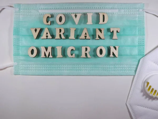 La parola covid variante omicron in lettere di legno sulla maschera — Foto Stock