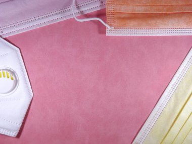 Tıbbi özelliklere sahip arkaplan çerçevesi farklı renkte maskeler ve solunum cihazlarıyla karşılaşıyor