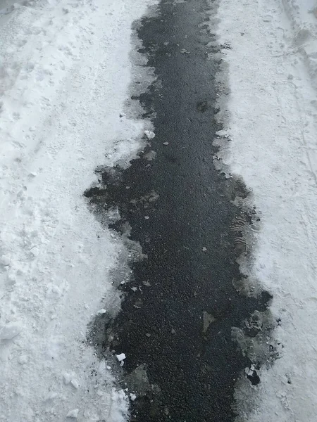 Asphaltpfad mit geschmolzenem Schnee in Nahaufnahme — Stockfoto