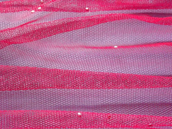 Różowy tiul w krotnie na fioletowym tle jako tło — Zdjęcie stockowe