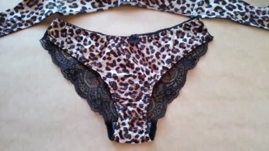 Leopard lingerie set on beige background close-up