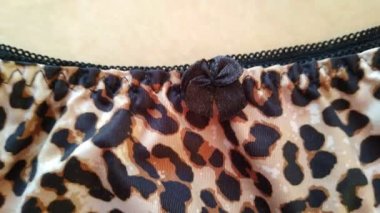 Leopard lingerie set on beige background close-up