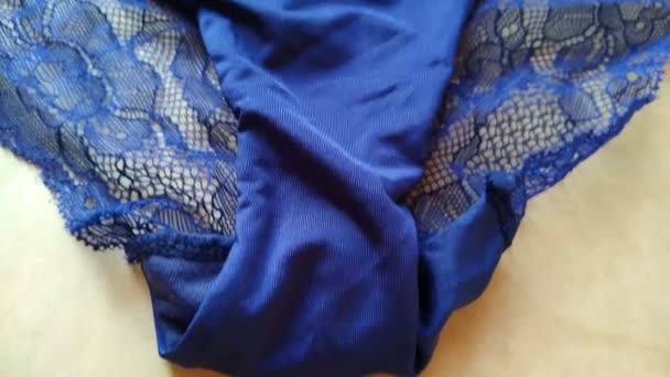 Black, dark blue erotic lingerie set on beige background close-up — Wideo stockowe