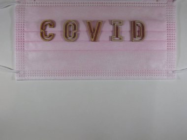 Yüz maskesi üzerinde ahşap harflerle 