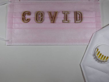 Yüz maskesi üzerinde ahşap harflerle 