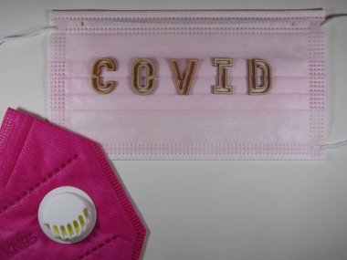 Yüz maskesi üzerinde ahşap harflerle 