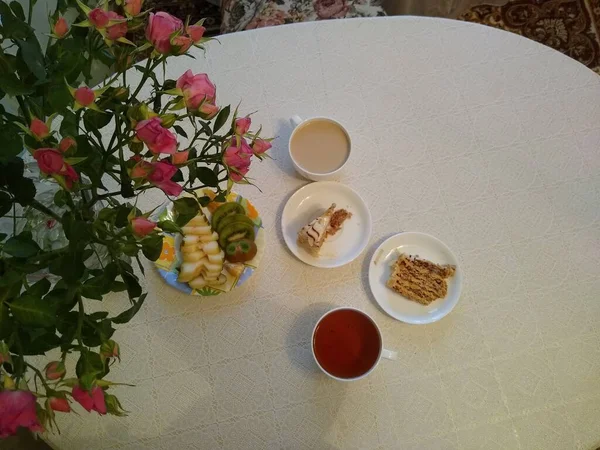 两人共进早餐，喝茶，蛋糕，花瓶里放玫瑰 — 图库照片