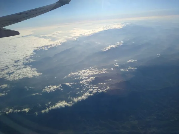 Pohled z okna letadla na pobřeží a mraky — Stock fotografie