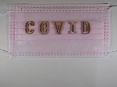 Yüz maskesi üzerinde ahşap harflerle 