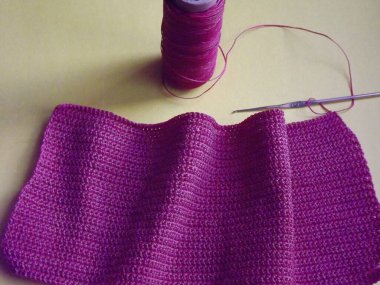 Mor bir arka planda pembe iplik işleme süreci