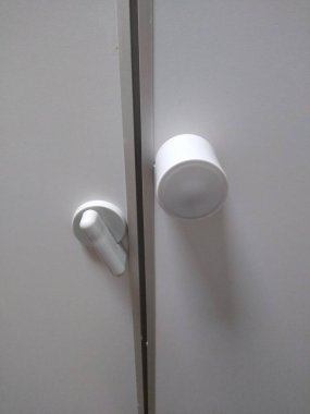 Tuvalet kapısının mandalı beyaz renkte.