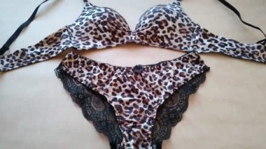 Leopard lingerie set on beige background close-up