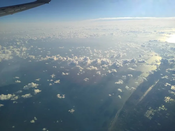 Vista da janela da aeronave no litoral e nuvens — Fotografia de Stock