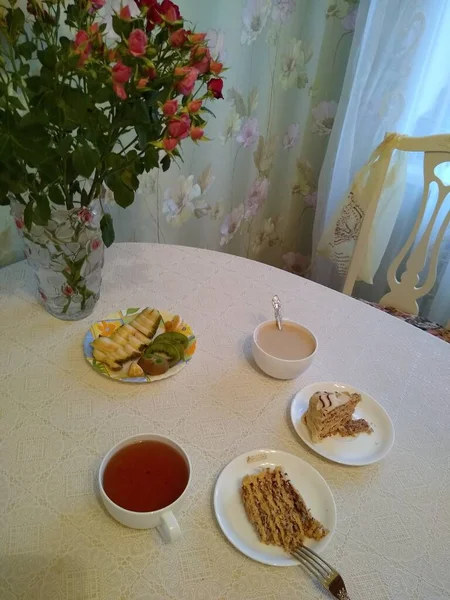Snídaně pro dva s čajem a koláčky s růžemi ve váze — Stock fotografie