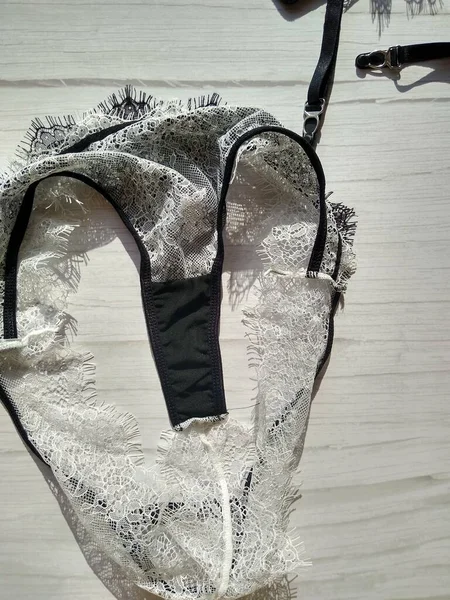 Sada černo-bílého guipure spodního prádla, skládající se z podprsenky, tanga a punčochového pásu — Stock fotografie