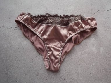 Gri arka planda ipek açık pembe kadın külotu