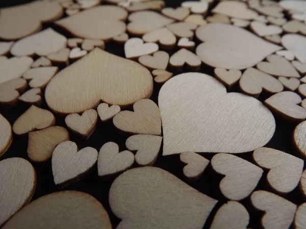 Wooden hearts on a black background as a postcard for the holidays — Stock Photo, Image