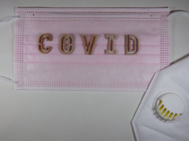 Yüz maskesi üzerinde ahşap harflerle 