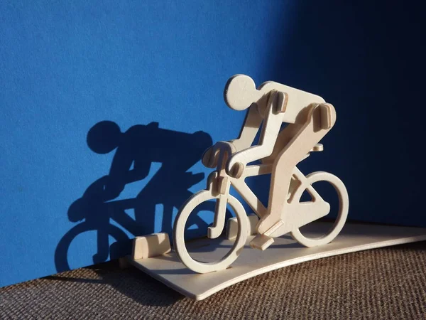 Radfahrer auf einem Fahrrad aus Holz auf blauem Hintergrund — Stockfoto