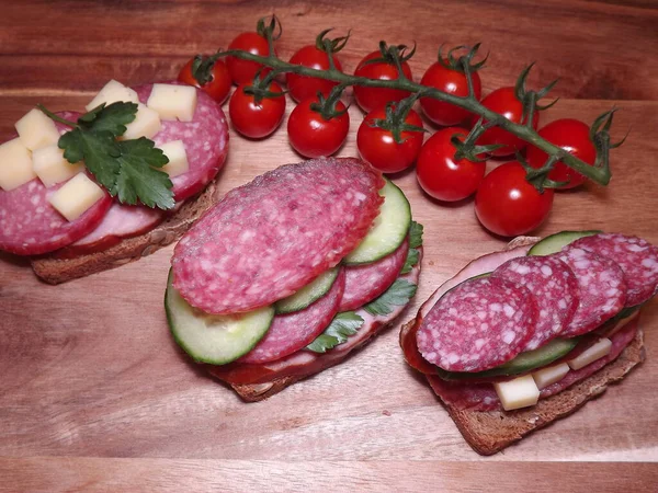 Sanduíche com diferentes tipos de salsicha e legumes, lanche rápido — Fotografia de Stock