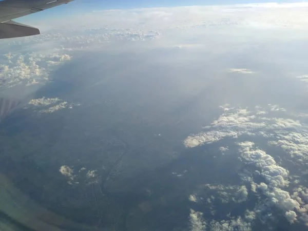 Kıyı şeridi ve bulutlardaki uçağın penceresinden bak. — Stok fotoğraf