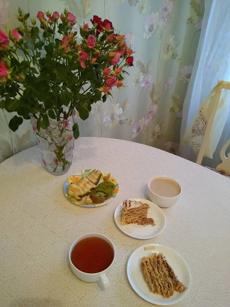 Colazione per due con tè e torte con rose in un vaso — Foto Stock