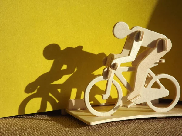 Велосипедист на велосипеде из дерева на желтом фоне — стоковое фото