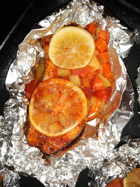 O processo de cozinhar peixe truta vermelha com limão e legumes em folha — Fotografia de Stock