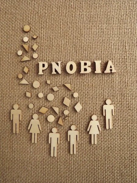 mental illness-phobia in the form of wooden letters and figures of people on a jute background