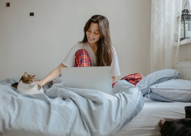 Cep telefonu olan kadın hasta yatağında yatıyor.