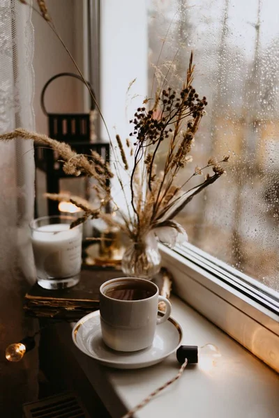 窓にはコーヒーカップとドライブラウンの花が — ストック写真