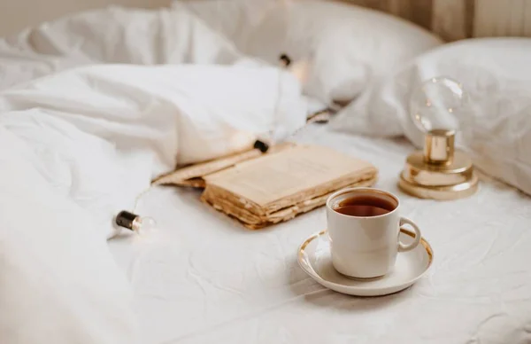 白いベッドでコーヒーと本を — ストック写真