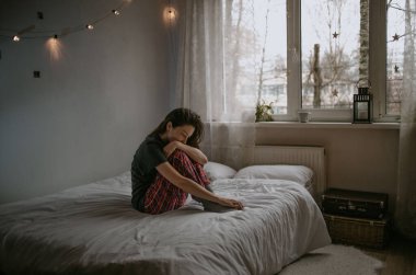 Evde cep telefonu olan genç bir kadın.