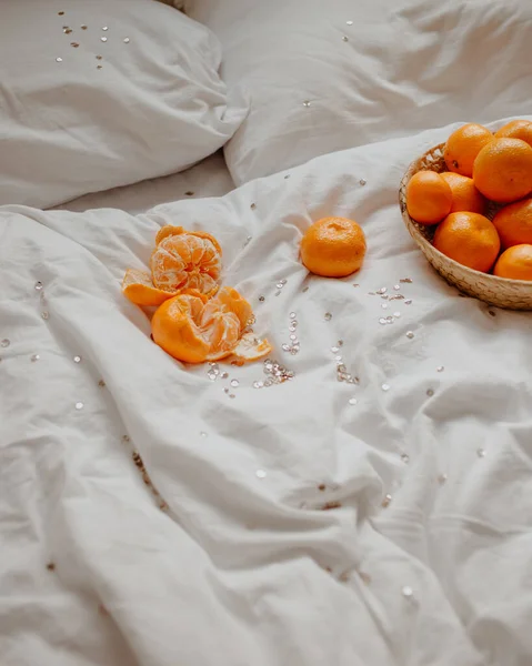 白いベッドの上にみかんと新年の輝きとフラットレイアウト — ストック写真