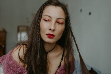 Örgülü ve septum halkalı genç bir kadın.