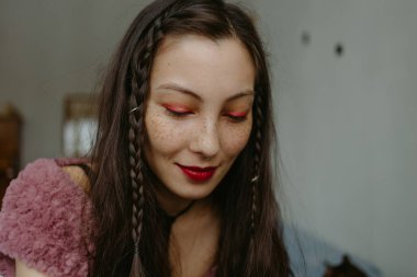 Örgülü ve septum halkalı genç bir kadın.