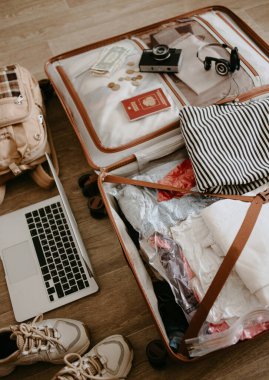 İçinde giysiler ve eşyalar olan bavulu aç