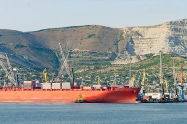 Vinçler ticari rıhtımda konteynır gemisi boşaltıyor. Novorossiysk, Rusya.