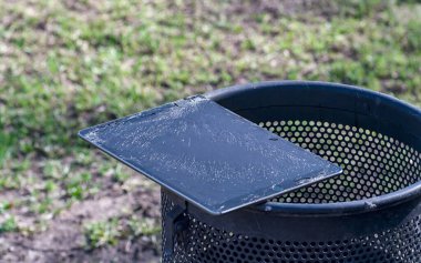 Son derece kırık ekranlı modern tablet çöpte yatıyor.