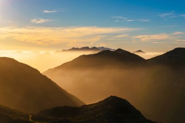 Gün batımında sisli dağ manzarası. Llanes, Asturias, İspanya 'daki Pea villa ve cuera sıradağları.