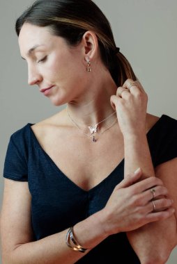 Beyaz kadın gümüş mücevherlerle poz veriyor. Mücevherli modelin stüdyo portresi.
