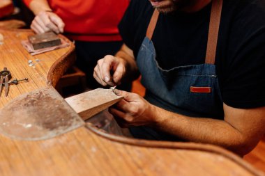 Tanımlanamayan kuyumcu atölyesindeki tezgahta gümüş bir yüzük yapıyor..