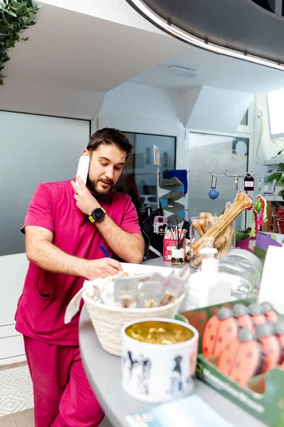Veteriner kliniğinde ve evcil hayvan dükkanında resepsiyonist olarak çalışan bir adam bir müşteriye telefonla cevap verir ve günlüğüne not alır..