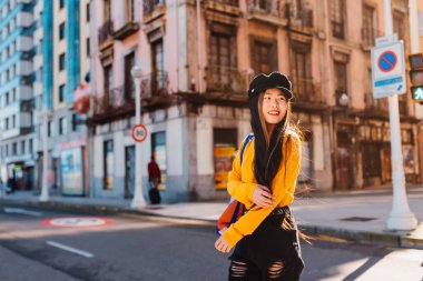 Asya 'lı genç bir kız Avrupa' da turizm yapıyor. Genç Çinli bir kadın güneşli bir günde yaya geçidinden geçiyor..