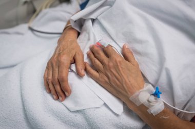 Hastanın eline bağlı bir nabız oksimetresi var. Hastanedeki yoğun bakımda.