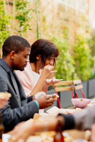 A couple of black people eating together in a restaurant with their friends.