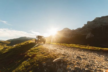 Güneşli bir günde 4x4 off-road arabası bir dağ yolunda gidiyor. araba macera gezisi
