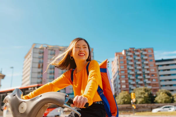 レンタル自転車でヨーロッパの都市でバックパック観光を持つアジアの女性 緑の輸送 — ストック写真