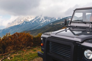 bulutlu bir günde dağlarda toprak yolda siyah bir off-road arabası. Seyahat ve macera